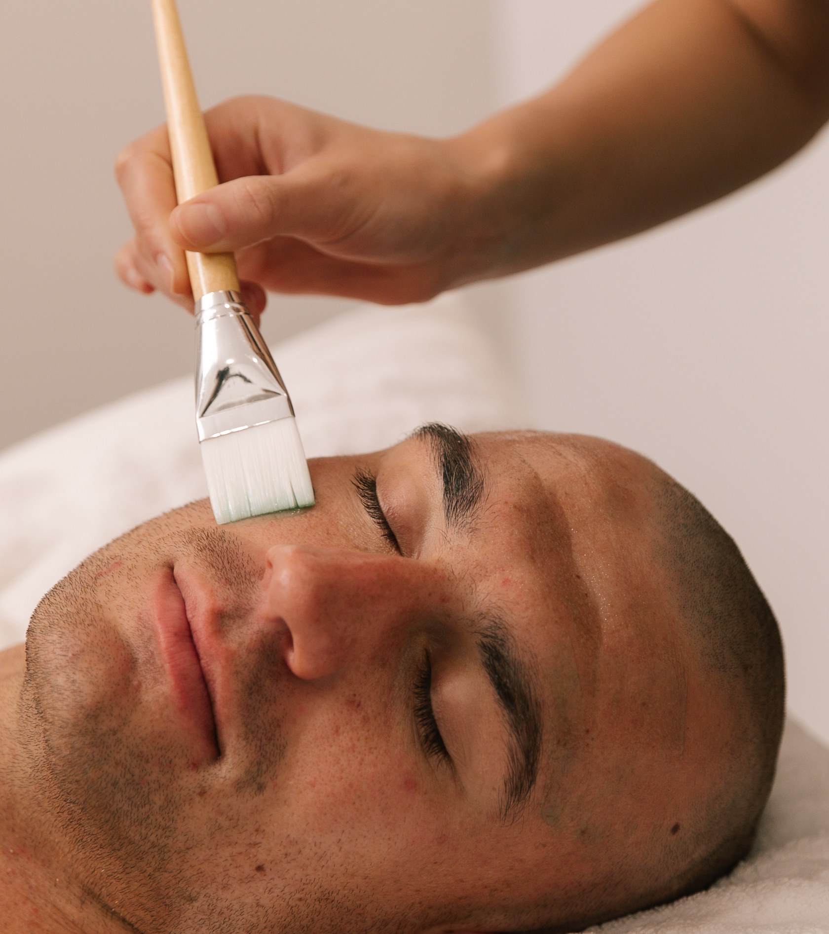 Dermal clinician applying a barrier repair facial mask with a brush at Plump Aesthetic Clinic South Yarra
