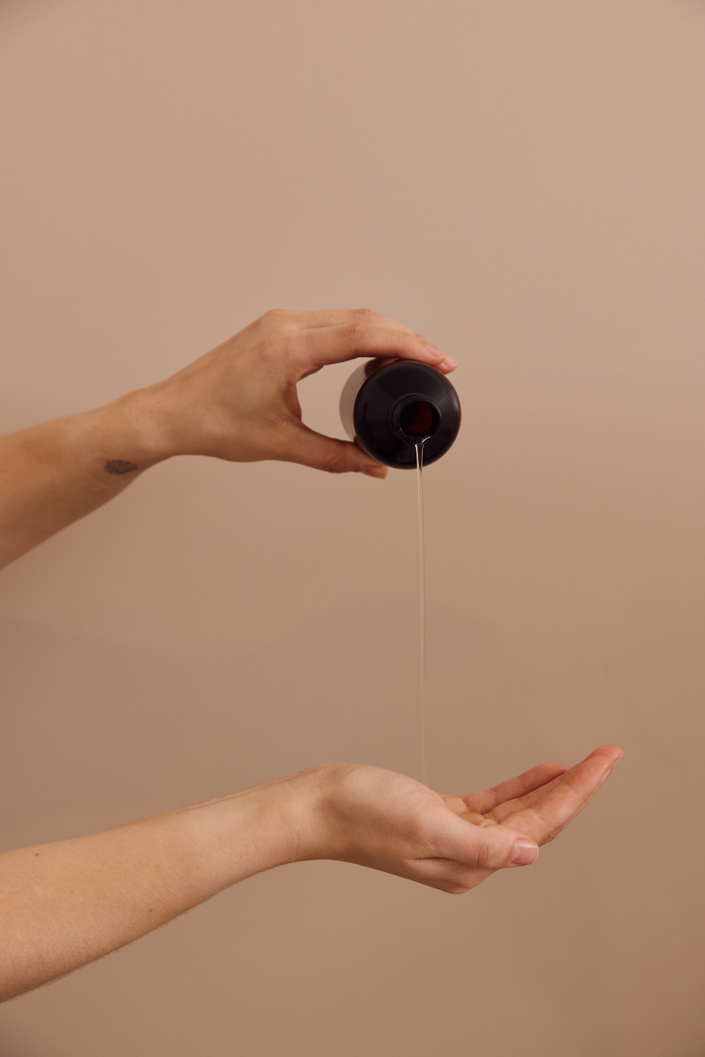 Massage oil being poured into a therapist hand before a holistic massage at Plump Aesthetic Clinic in South Yarra