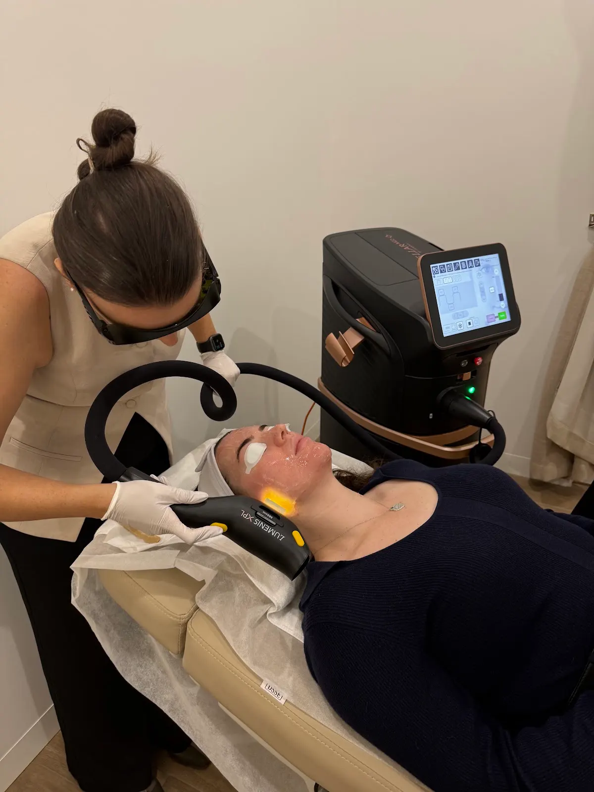 Plump clinician performing an IPL treatment with the Lumenis Stellar M22 XPL device on a client's face