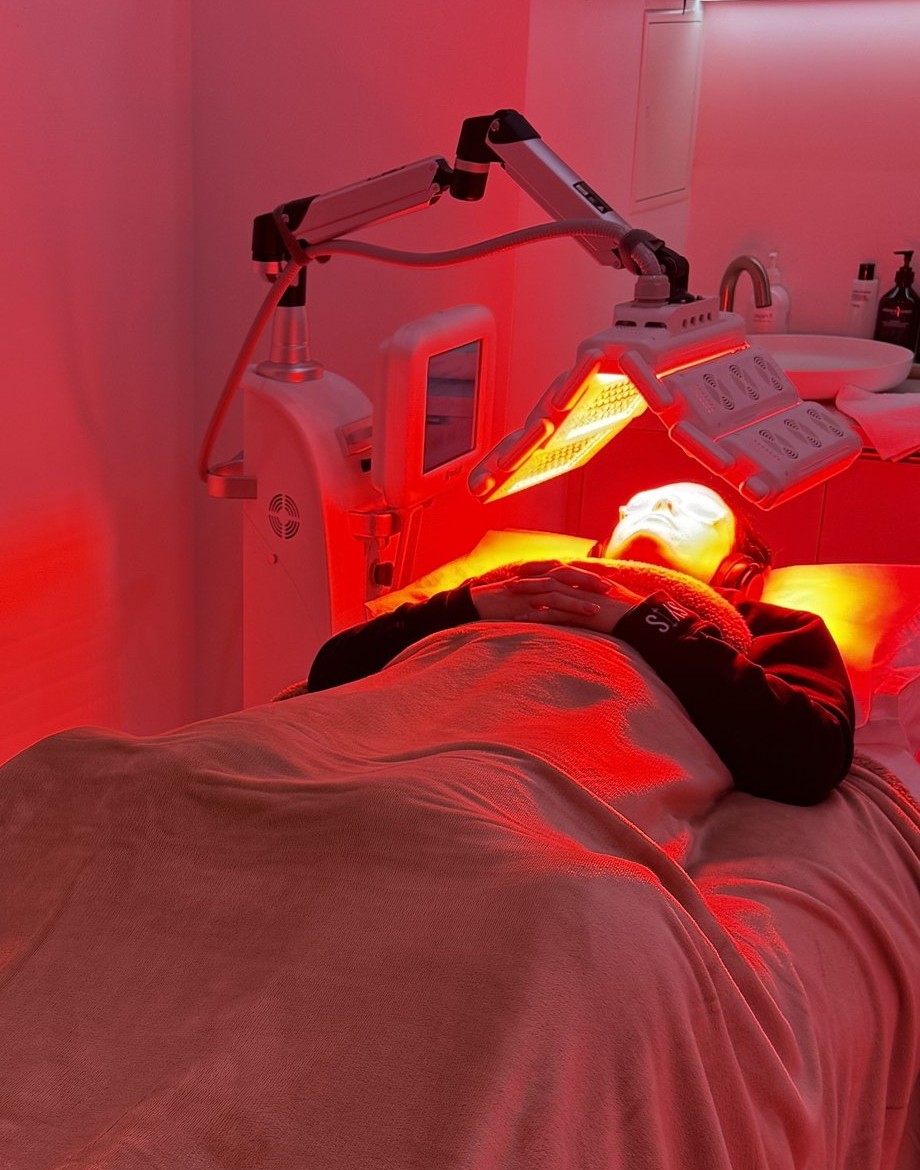 Client receiving MediLUX LED light therapy under the panel in the treatment room at Plump Aesthetic Clinic South Yarra