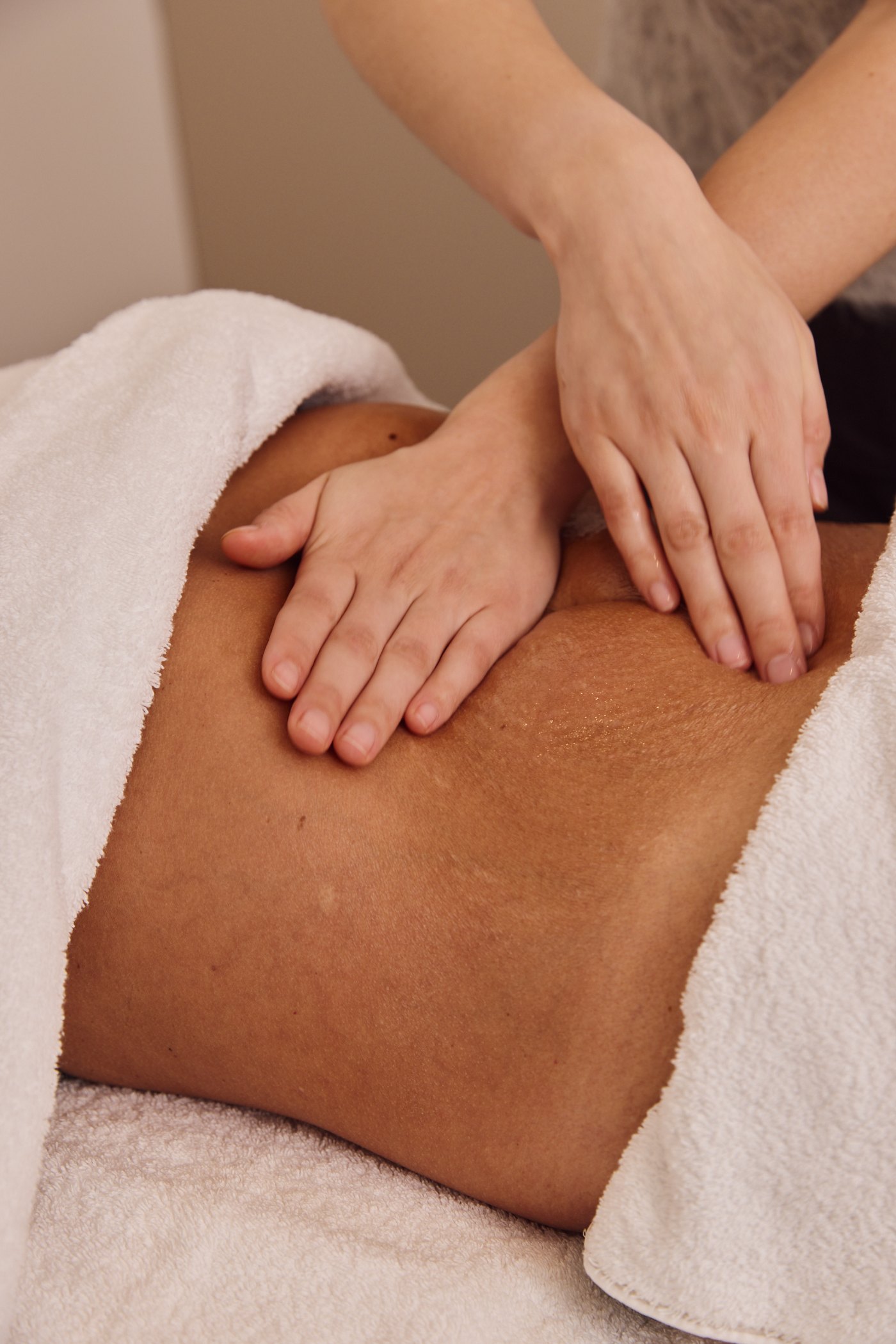 Therapist performing an abdominal lymphatic drainage massage at Plump Aesthetic Clinic in South Yarra