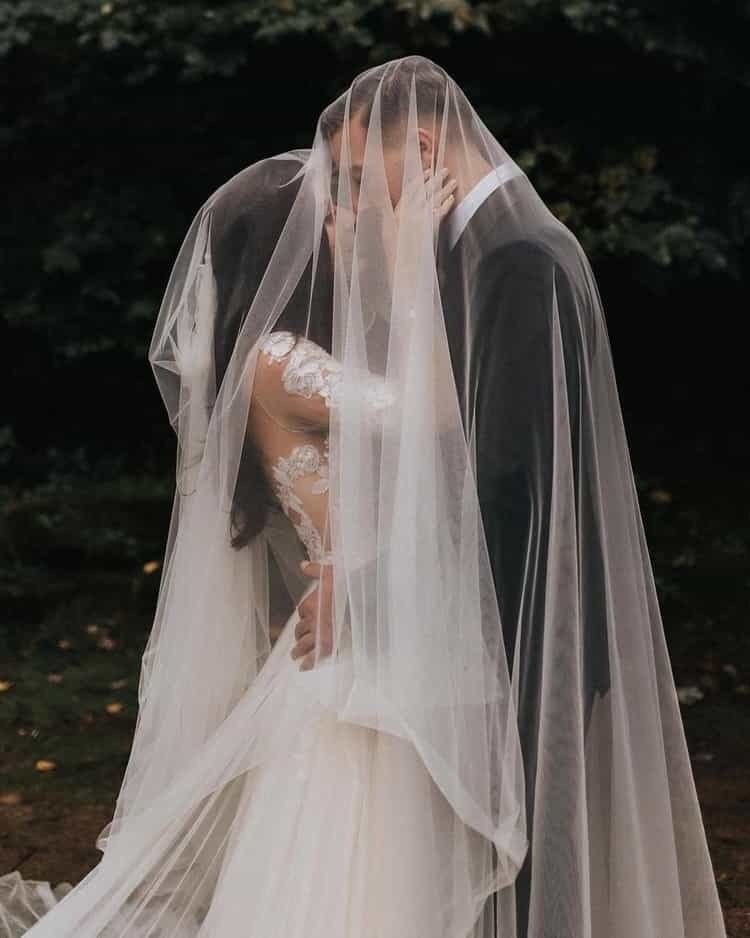 Bride and groom sharing a kiss beneath her veil