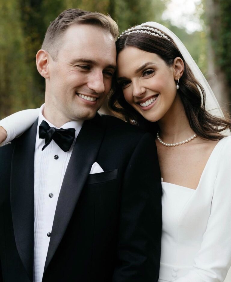Smiling bride and groom posing together outdoors