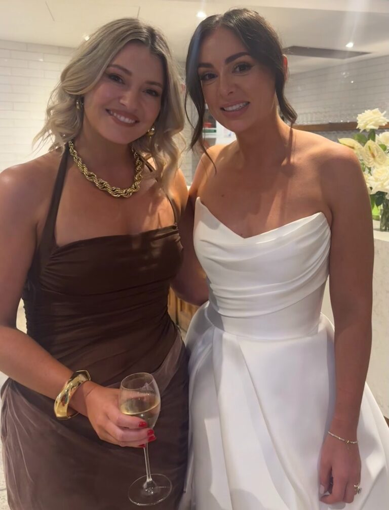 Bride in a strapless ivory gown with a wedding guest